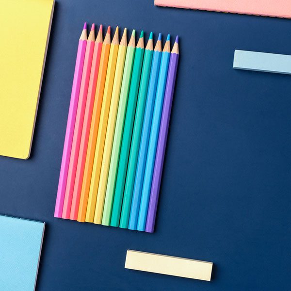 top view pastel notebook with pencil and stationery on navy blue table background